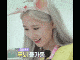 a woman wearing a headband with bunny ears is smiling in a korean language