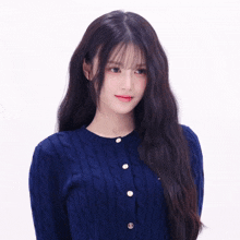 a woman with long dark hair wearing a blue sweater