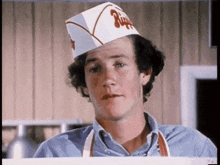 a man wearing a chef 's hat is standing in a kitchen .