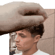 a hand is holding a man 's head in a pixel art .