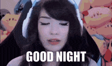 a girl with her eyes closed says " good night " in front of kirby balloons