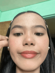 a close up of a woman 's face with her ear being touched