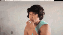 a man in a blue tank top is coughing while looking at a screen that says all my files