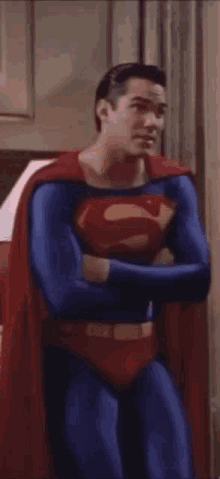 a man in a superman costume with his arms crossed .