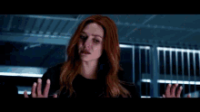 a person is standing in a dark room with a red light coming out of the ceiling .