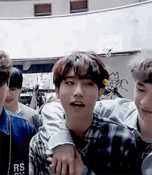 a group of young men are hugging each other in a room .