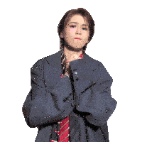 a woman wearing a suit and tie with her hands folded