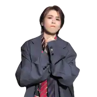 a woman wearing a suit and tie with her hands folded