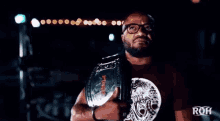 a man wearing glasses is holding a world heavyweight championship belt