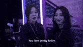 a couple of women are standing next to each other in a dark room .