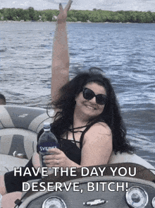 a woman on a boat holding a bottle of svedka vodka