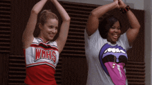 two cheerleaders wearing wmhs shirts are dancing together