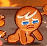 a gingerbread cookie is sitting on the floor with a sad face on his face .