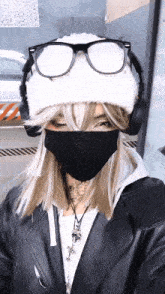 a woman wearing a mask and headphones is standing in front of a building
