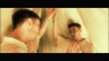 a blurry image of a man looking at his reflection in a mirror