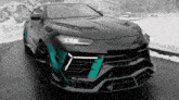 a black sports car with a green stripe on the front is parked in the snow