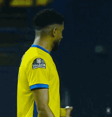 a soccer player wearing a yellow shirt with the number 7 on it