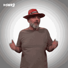 a man with a beard wearing a red hat with swr3 on it