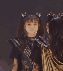a girl with pigtails and spikes on her hair looks at the camera
