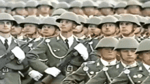 a group of soldiers are marching in a line with their helmets on