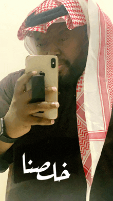 a man taking a picture of himself with arabic writing on it