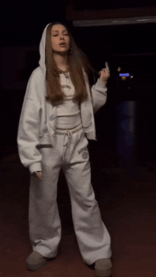 a woman wearing a white hoodie and sweatpants with the word kansas on the front