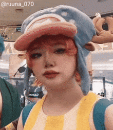 a woman wearing a hat and a yellow and white striped shirt has the number 070 on her shoulder