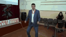 a man in a suit is dancing in front of a sign that says " aahi tepteh "