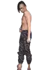 a shirtless man in louis vuitton pants is pointing upwards