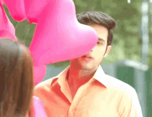 a man stands in front of a bunch of pink hearts