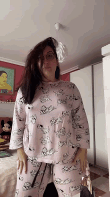 a woman in a dalmatian pajama set stands in a bedroom