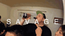 a man is drinking from a bottle with the word savage above him