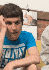 a young man wearing a blue shirt that says volyat on it