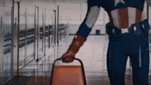 a man in a superhero costume is holding a chair in a hallway