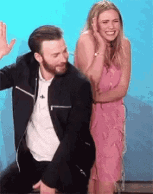 a man and a woman are sitting next to each other and the woman is smiling .