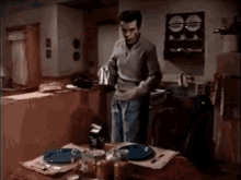 a man is pouring coffee into a cup while standing at a table .