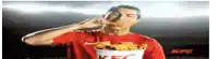 a man in a kfc shirt is eating a fried chicken