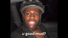 a man wearing a helmet with the words u good mud written below him