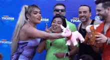 a group of people standing in front of a blue wall that says feria yucatan on it