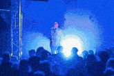 a man is singing into a microphone in front of a crowd