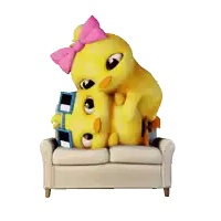 a stuffed duck with a pink bow sits on a couch