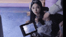 a woman is sitting in front of a camera with the word gif on the bottom right