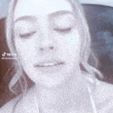 a close up of a woman 's face with her eyes closed and a tiktok watermark