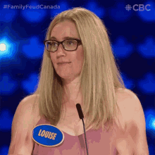 a woman with glasses and a name tag that says louise on it