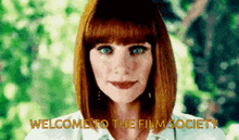 a woman with red hair is standing in front of a green background with the words welcome to the film society .