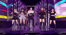 a group of women are standing on a stage and dancing together .