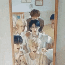 a group of young men are standing next to each other in front of a mirror .