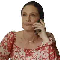 a woman wearing a red and white floral dress is talking on a cell phone