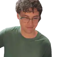 a man wearing glasses and a green shirt looks down