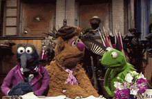 a group of sesame street characters sitting around a table including kermit the frog